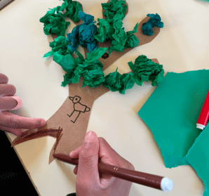 Mains d'enfants fabriquant un arbre en papier et pâte à modeler
