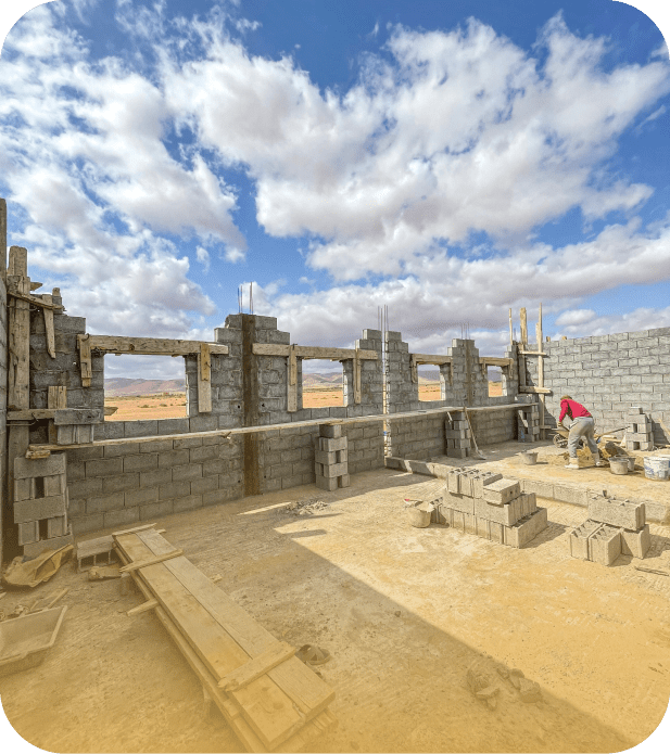 Chantier de construction d'un bâtiment en parpaings avec un ouvrier
